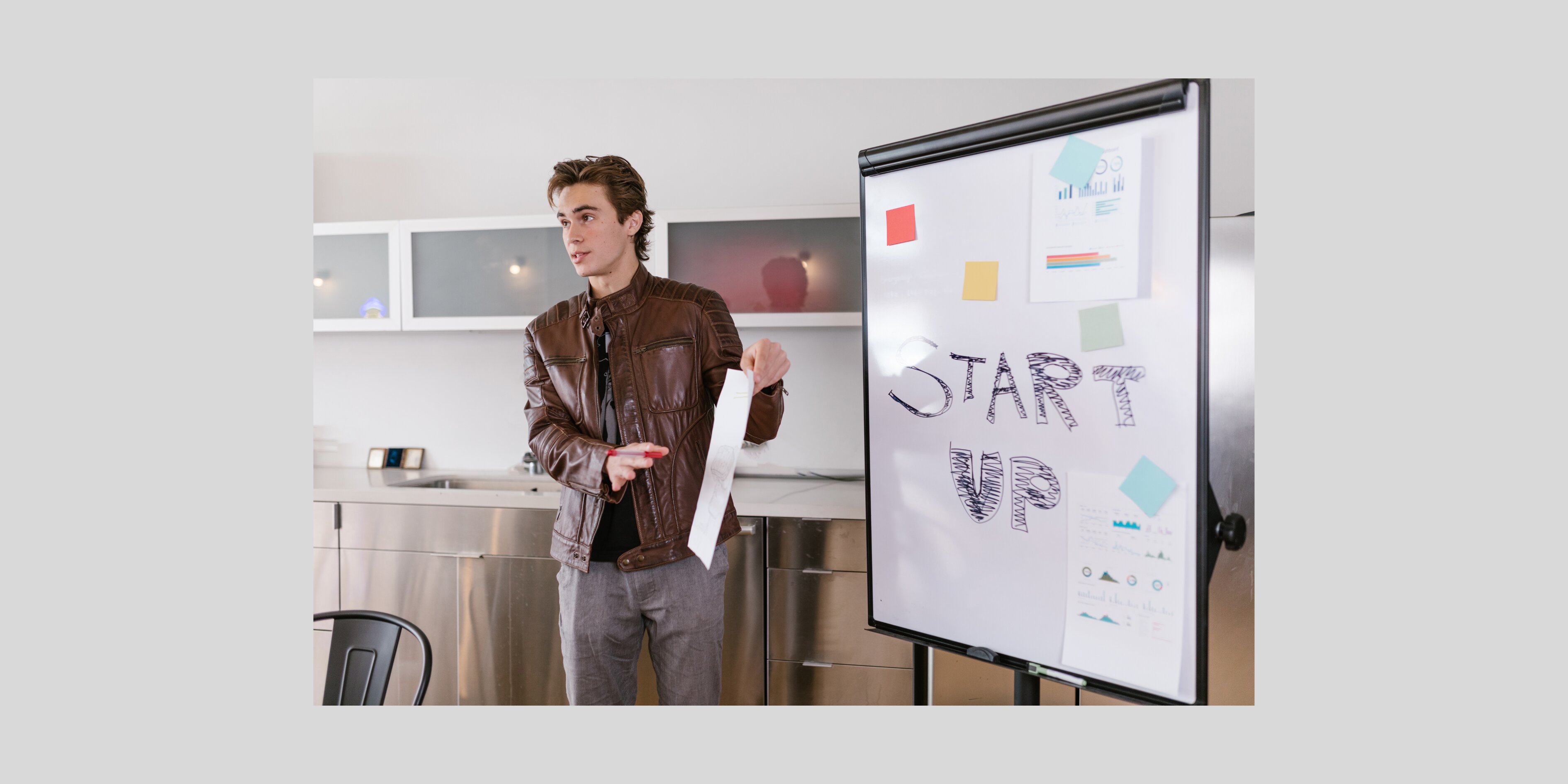 a person standing in front of a notice board with a chart about start ups 